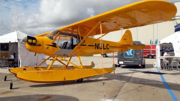 Ein gelbes Wasserflugzeug steht auf einem Flugplatz.