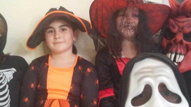 Eine Gruppe von Kindern, verkleidet für Halloween, posiert für ein Foto.