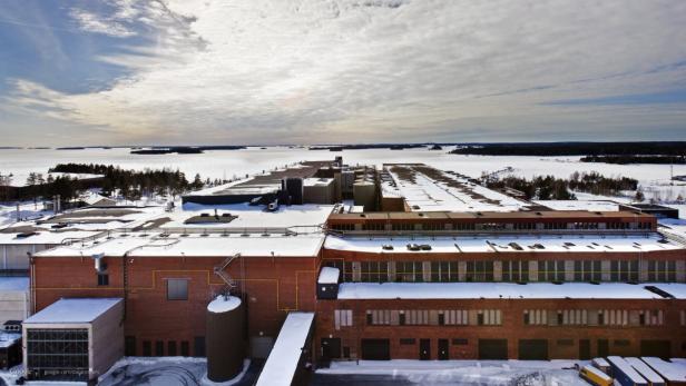 Luftaufnahme eines großen, schneebedeckten Industriegebäudes an einem Wintertag.