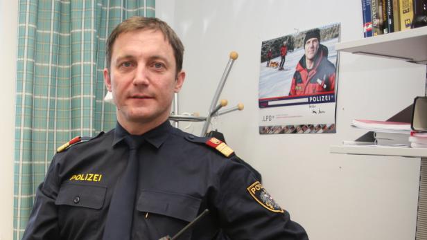 Ein Polizist in Uniform sitzt in einem Büro.