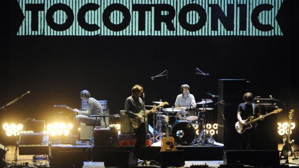 Die deutsche Band Tocotronic spielt ein Konzert auf einer Bühne.