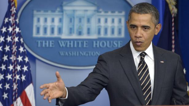 Barack Obama spricht vor dem Hintergrund des White House Logos.