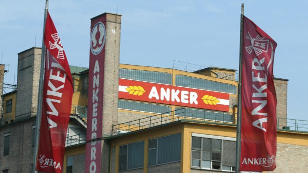 Das Gebäude der Anker Brauerei mit zwei roten Anker-Flaggen im Vordergrund.
