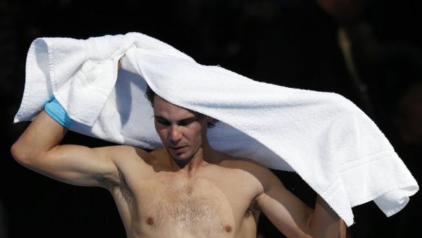 Rafael Nadal trocknet sich mit einem weißen Handtuch ab.
