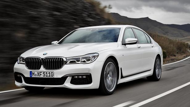 Ein weißer BMW der 7er-Reihe fährt auf einer Landstraße.