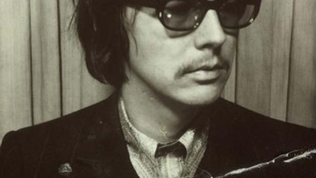 Ein Mann mit Brille und Schnurrbart in einem beschädigten Schwarzweißfoto.