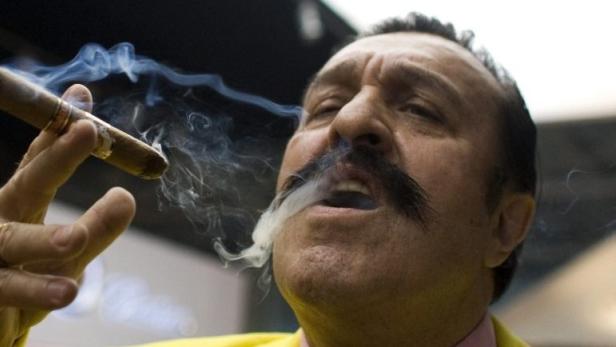 A man smokes a cigar during the opening night of the Millionaire Fair in Moscow November 27, 2008. Picture taken November 27, 2008. REUTERS/Thomas Peter (RUSSIA)