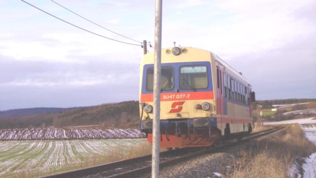 Ein Triebwagen der ÖBB auf einer winterlichen Strecke.