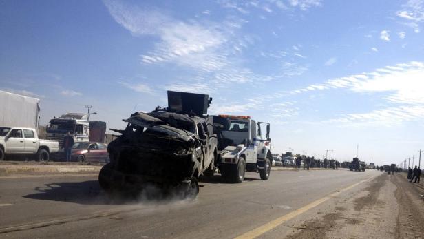 A police vehicle is towed after a suicide bomb attack in Taji, 20 km (12 miles) north of Baghdad Febraury 5, 2013. A suicide bomber detonated a car packed with explosives at an Iraqi army checkpoint north of Baghdad on Tuesday, killing at least three people, police said. REUTERS/Mohammed Ameen (IRAQ - Tags: CIVIL UNREST CRIME LAW)