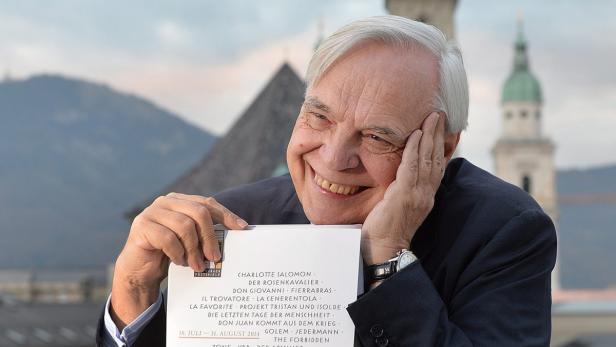 Ein lächelnder Mann präsentiert das Programm der Salzburger Festspiele 2014.