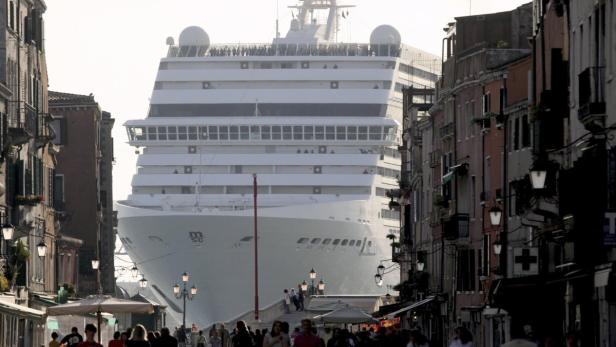 Ein großes Kreuzfahrtschiff fährt durch einen Kanal in Venedig.