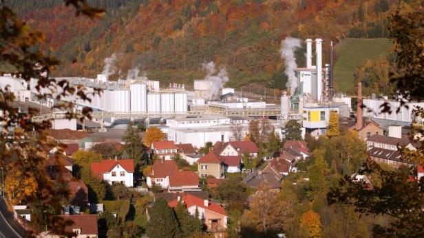 Blick auf eine Fabrik am Rande einer kleinen Stadt im Herbst.