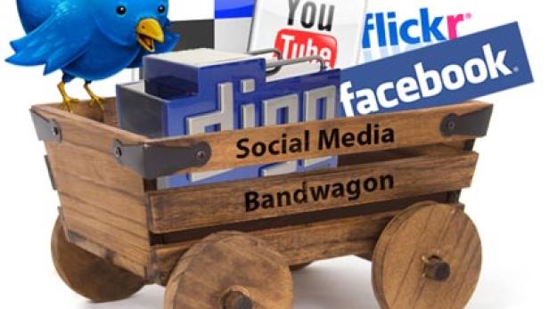 Ein hölzerner Karren, beladen mit Logos von Social-Media-Plattformen wie Twitter, YouTube und Facebook.