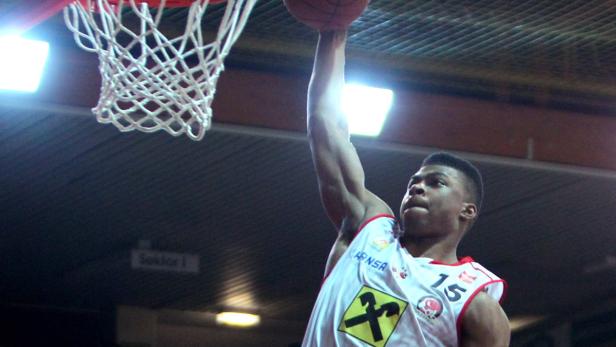 Ein Basketballspieler beim Dunking in einem Spiel.