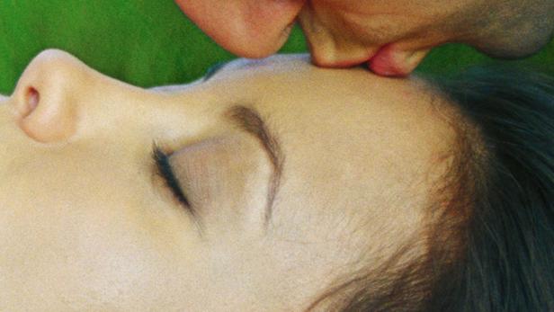 Ein Mann küsst eine Frau auf die Stirn.