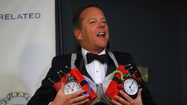 Kiefer Sutherland mit einer Attrappe einer Bombe mit Weckern bei einer Veranstaltung.