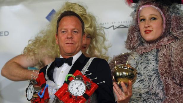 Kiefer Sutherland mit einer Spielzeugbombe und eine Frau mit einem goldenen Topf bei einer Kostümveranstaltung.