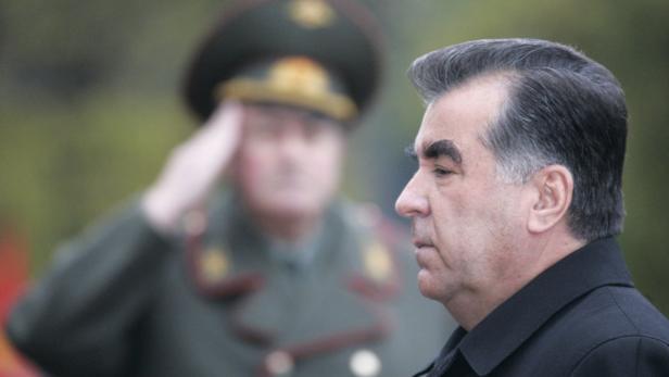 Emomalij Rahmon, der Präsident Tadschikistans, im Profil, während ein Soldat im Hintergrund salutiert.