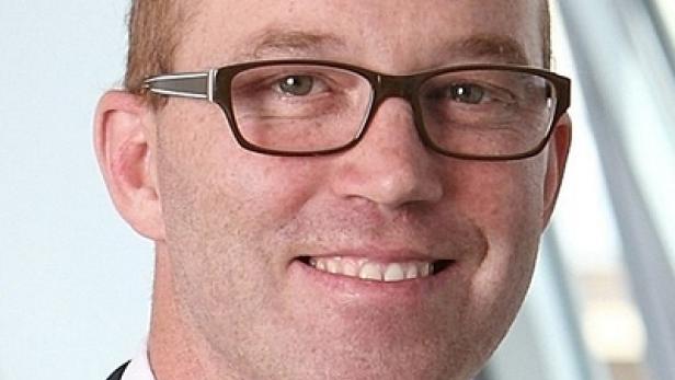 Ein Mann mit Brille lächelt in die Kamera.