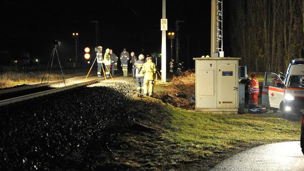 Einsatzkräfte von Feuerwehr und Rettungsdienst sind nachts an einem Bahngleis im Einsatz.