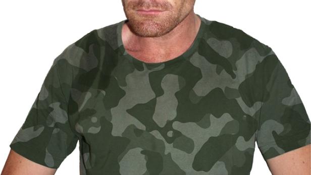 Ein Mann mit Kriegsbemalung und einem T-Shirt mit Tarnmuster blickt grimmig in die Kamera.