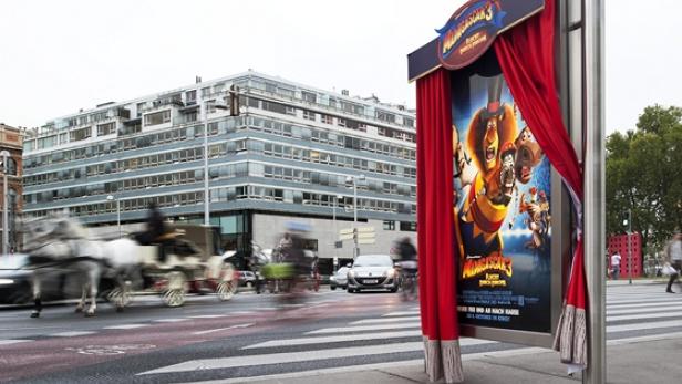 Ein „Madagascar 3“-Filmplakat mit rotem Vorhang steht an einer Straße in Wien.