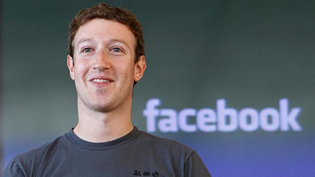 Mark Zuckerberg steht vor einem Facebook-Logo.