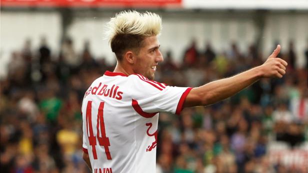 Ein Fußballspieler von Red Bull mit blond gefärbten Haaren gibt ein positives Zeichen.