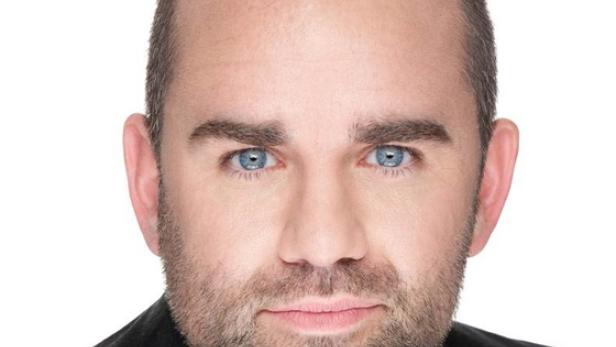 Ein Mann mit Bart und blauen Augen blickt in die Kamera.
