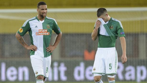 Zwei Fußballspieler von Rapid Wien stehen enttäuscht auf dem Spielfeld.
