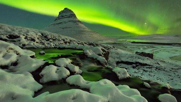 Nordlichter über dem verschneiten Kirkjufell in Island.