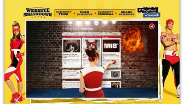 Zwei Personen in rot-weißen Kostümen stehen vor einer Website namens „Website Smashdown“, die eine Explosion zeigt.