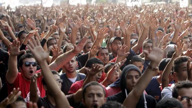 Eine große Menschenmenge demonstriert mit erhobenen Händen.