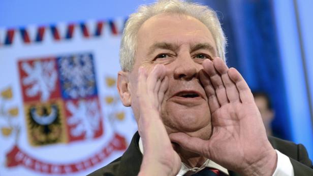 Miloš Zeman spricht mit erhobenen Händen vor einem Wappen der Tschechischen Republik.