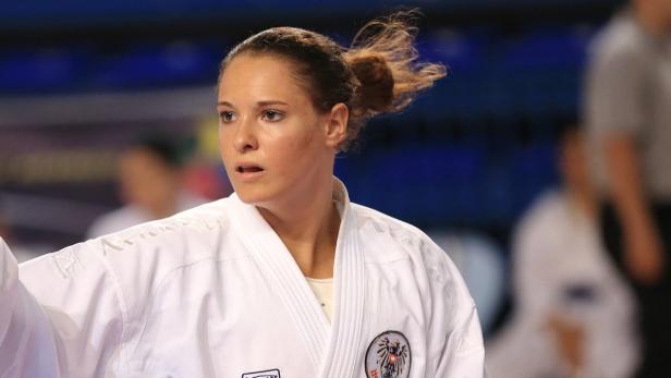Eine Karateka im weißen Gi mit dem österreichischen Wappen auf der Brust.
