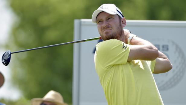 Ein Golfspieler schwingt seinen Schläger auf einem Golfplatz.