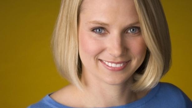 Eine Frau mit blonden Haaren und blauen Augen lächelt.