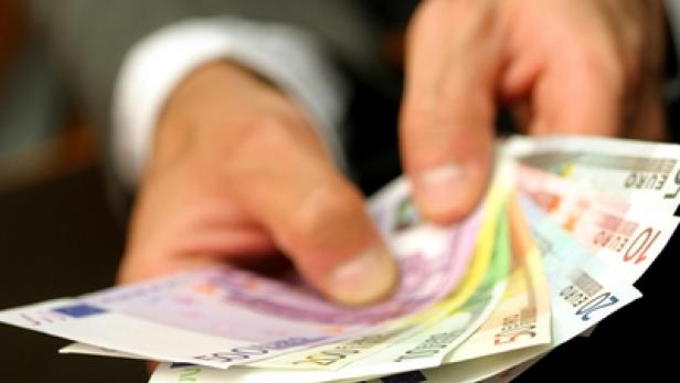 Eine Hand hält einen Fächer aus Euro-Banknoten unterschiedlicher Werte.
