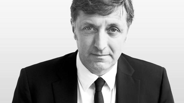 Ein Mann in Anzug und Krawatte blickt in die Kamera.