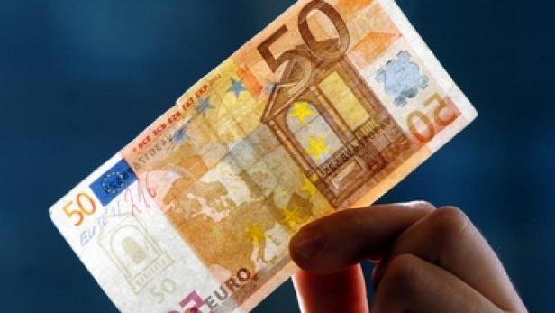 Eine Hand hält einen 50-Euro-Schein.