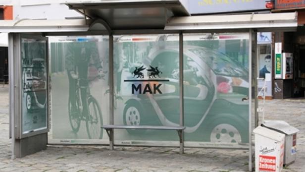Eine Bushaltestelle mit Werbung für das MAK (Museum für angewandte Kunst).
