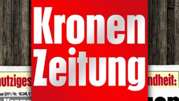 Die Titelseite der „Kronen Zeitung“ vor einem hölzernen Hintergrund.