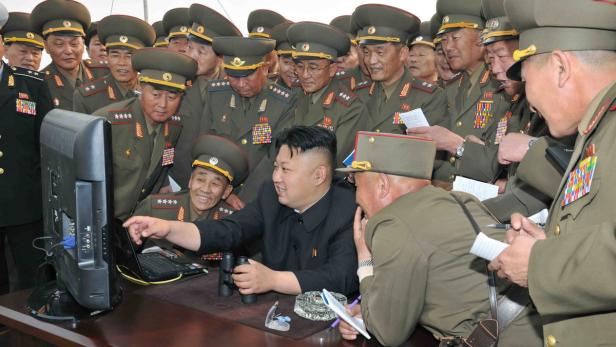 Kim Jong-un betrachtet mit Militärs einen Bildschirm und ein Laptop.