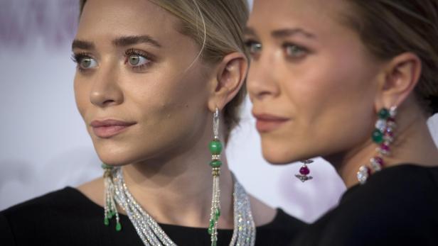 Nahaufnahme von Mary-Kate und Ashley Olsen mit auffälligem Schmuck.