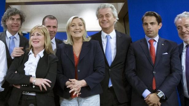 Eine Gruppe europäischer Politiker posiert vor einem blauen Hintergrund.