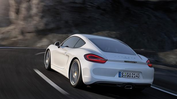Ein weißer Porsche Cayman fährt auf einer kurvigen Straße.