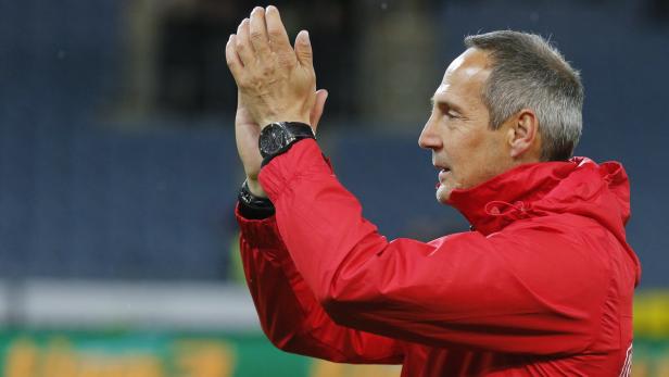 Ein Mann in roter Jacke klatscht Beifall.