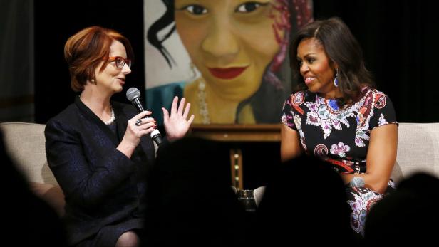 Julia Gillard und Michelle Obama sitzen auf einer Couch und sprechen miteinander.