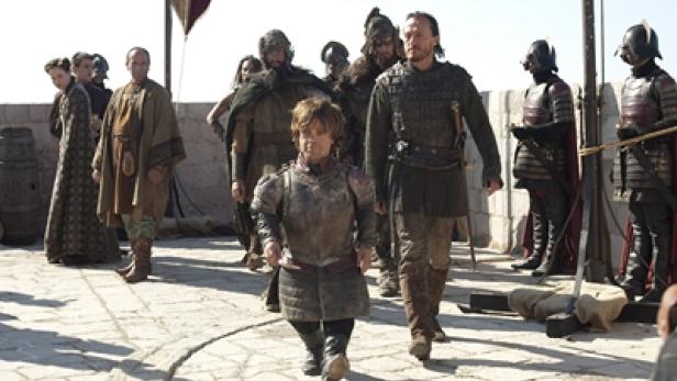 Tyrion Lennister in Rüstung, begleitet von Bronn und anderen Charakteren aus „Game of Thrones“.