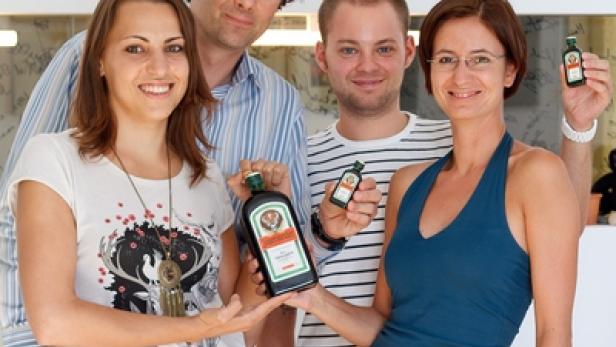 Vier Personen präsentieren eine Flasche und Miniaturflaschen Jägermeister.